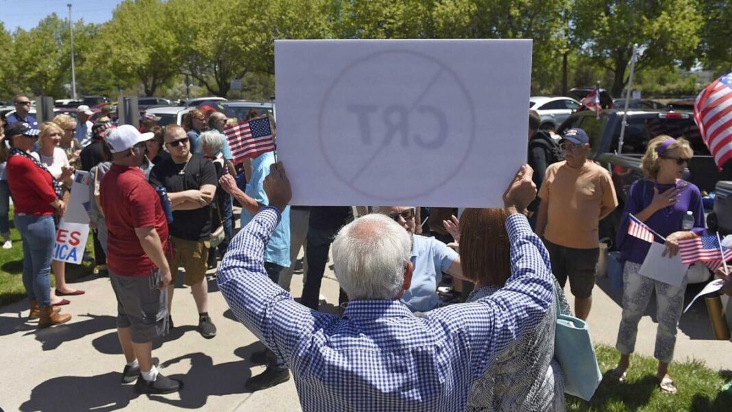 A man holds up a sign against Critical Race Theory