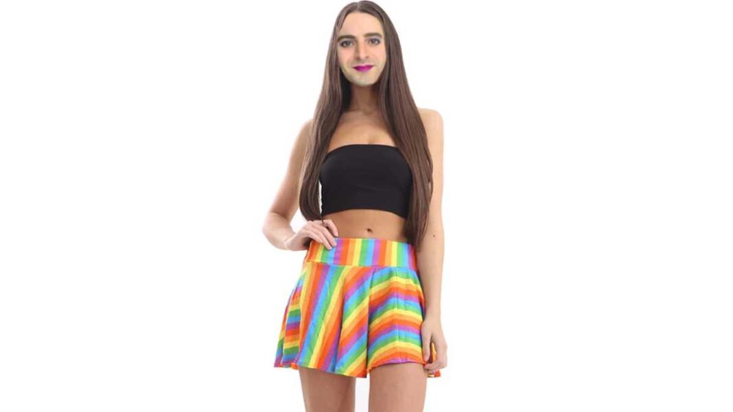 Bearded transwoman dressed in a gay pride flag miniskirt. 