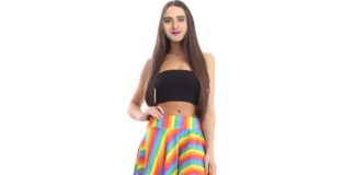Bearded transwoman dressed in a gay pride flag miniskirt. 