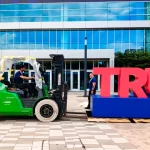 Workers disassemble the words "TRUMP 2024" outside the Fiserv Forum