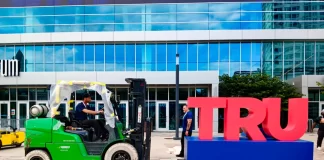 Workers disassemble the words "TRUMP 2024" outside the Fiserv Forum