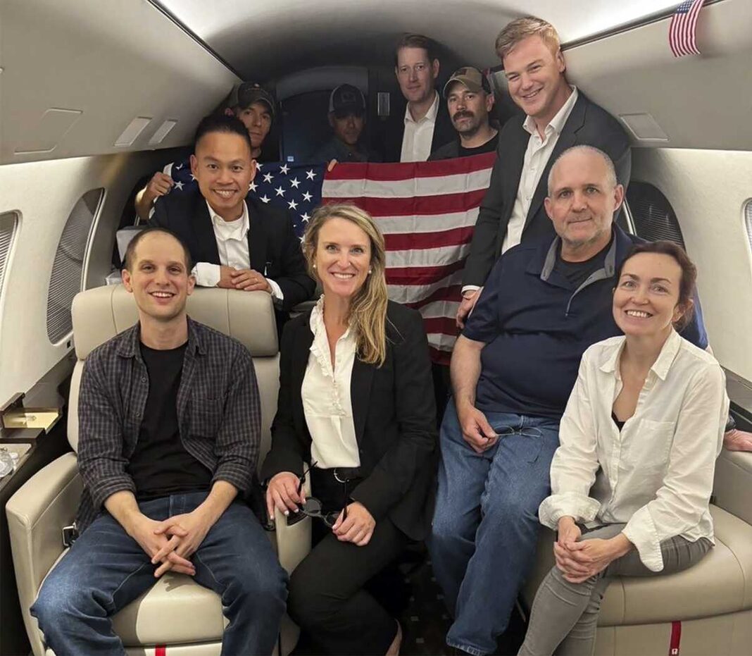 This image released by the White House shows Evan Gershkovich, left, Alsu Kurmasheva, right, and Paul Whelan, second from right, and others aboard a plane on Aug. 1, 2024, following their release from Russian captivity.