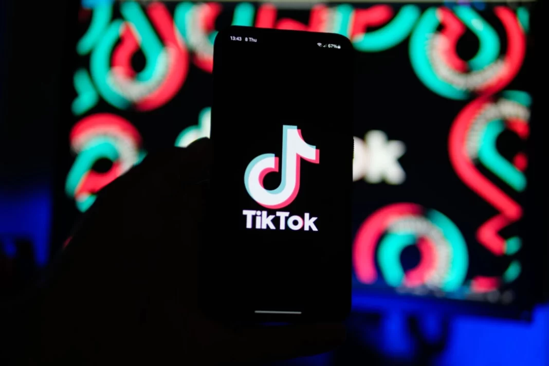 A man holds a phone displaying the TikTok app, on Aug. 11, 2024