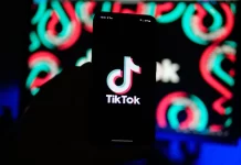 A man holds a phone displaying the TikTok app, on Aug. 11, 2024