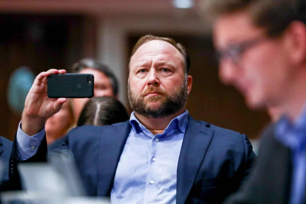 InfoWars founder Alex Jones takes photos at a hearing