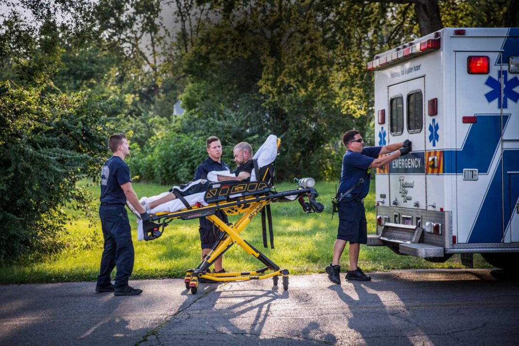 Paramedics attend to a man who is overdosing