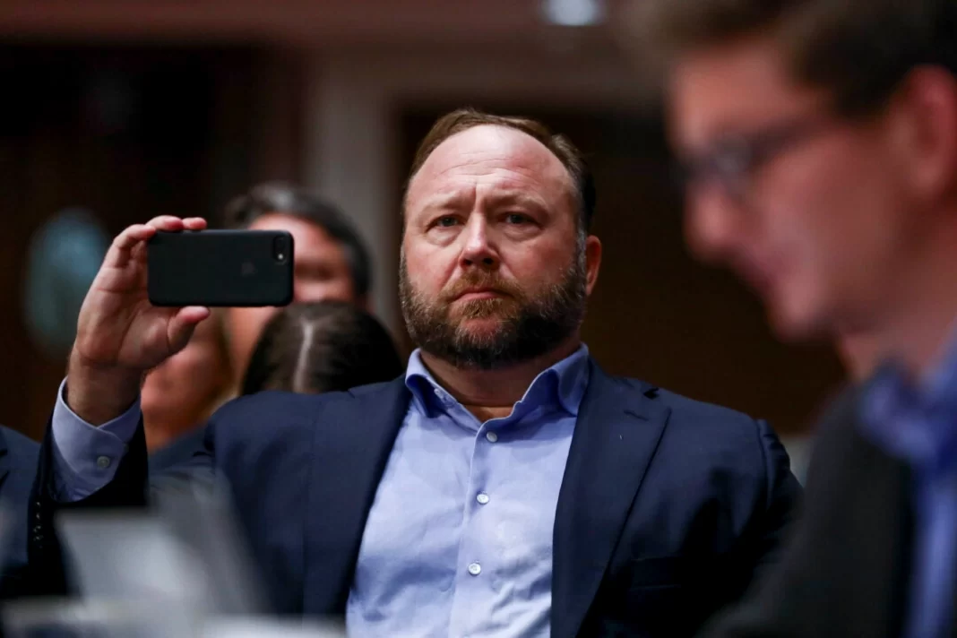 InfoWars founder Alex Jones takes photos at a hearing