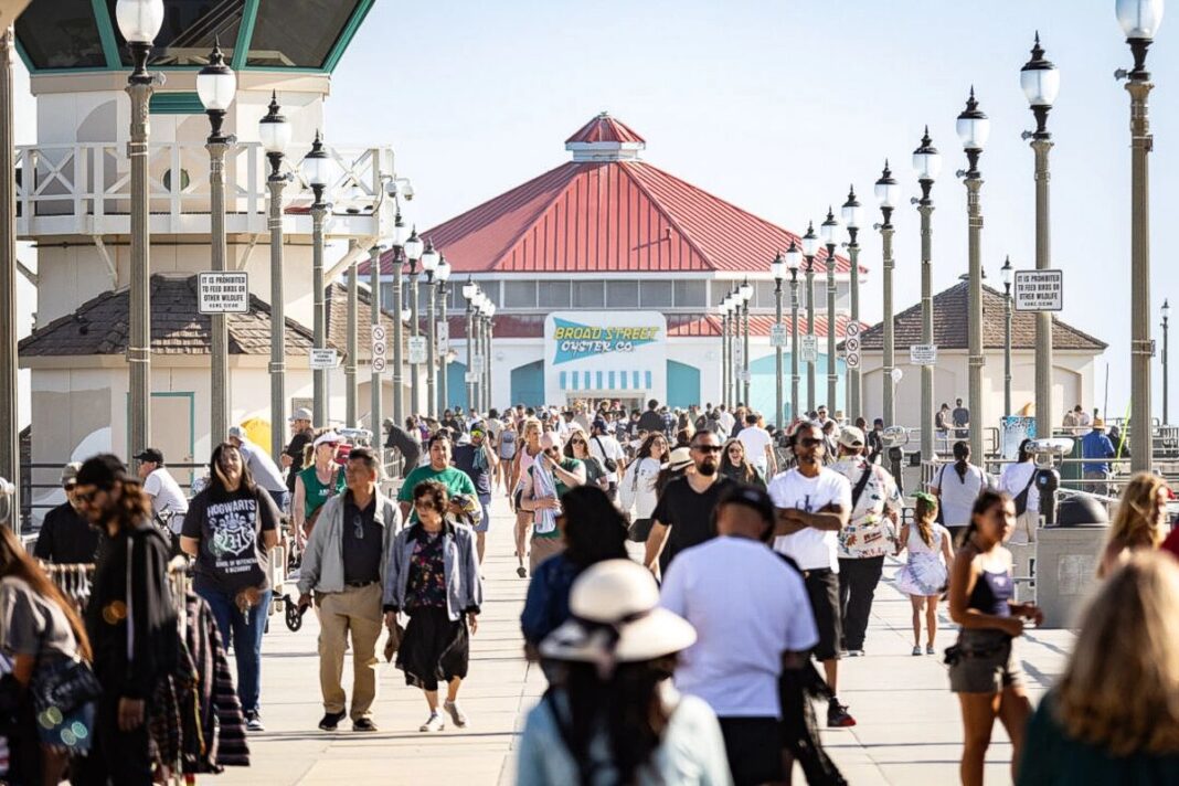 Visitors walk on the pier in Huntington Beach, Calif., on June 19, 2024.